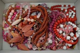 A collection of pink and red decorative necklaces.