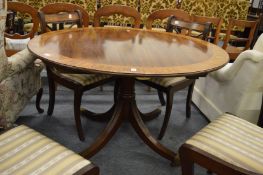 A good Regency style mahogany tulip wood and rosewood banded circular extending dining table.