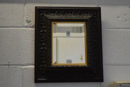 A small mirror with decoratively moulded frame.