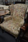 A Georgian style floral upholstered wing armchair.