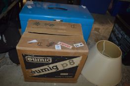 A Eumig P8 projector, boxed, a tin storage box and a lamp shade.