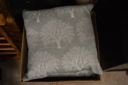 A set of four cushions, pale green with a tree design.