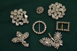 Seven diamante brooches.