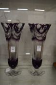 A pair of amethyst tinted pedestal vases.