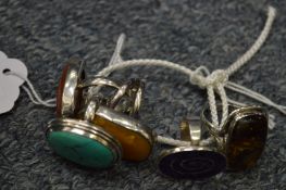 A collection of five decorative silver rings.