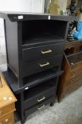 A pair of black painted bedside chests.