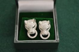 A pair of silver and panther stud earrings.