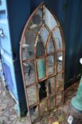 A cast iron arch shaped panel with mirrored glass.