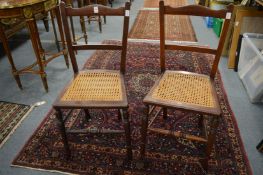 A pair of mahogany and cane seated occasional chairs.