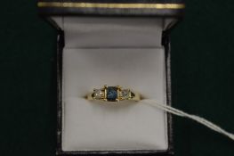 A 14ct gold blue diamond and clear diamond three stone princes cut ring.