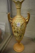 A large blush ivory floral decorated porcelain twin handled vase (repairs).