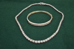 A silver and diamonti necklace and bangle.
