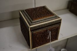 An Eastern carved sandalwood and inlaid tea caddy.