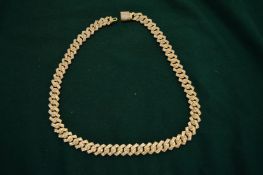 A heavy gilt metal and diamante set curb link necklace.