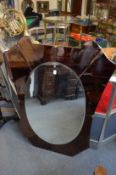 A 1950's Italian wall mirror with oval mirror plate within a shaped coloured mirrored surround.
