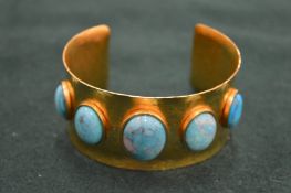 A gilt metal and turquoise inset bangle.