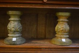 A pair of composite stone candle stands.