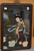 A Chinese reverse painting on glass depicting a young lady with a fan.