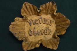 A cast metal dish 'Victory Copper'.