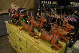 Santa on his sleigh being pulled by four reindeer.