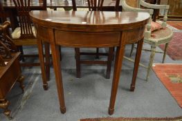 A 19th century mahogany demi lune fold-over tea table.