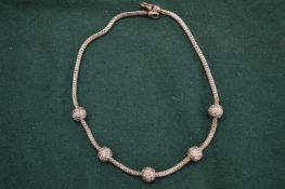 A silver chain mounted with balls.