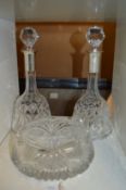 A pair of cut glass decanters with silver collars and a cut glass bowl.