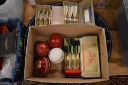 A dartboard, old darts and cricket balls.