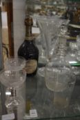 A pair of etched glass champagne bowls, bottle of champagne, etched beaker, decanter and trumpet