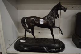 A cast bronze model of a horse on a marble base.