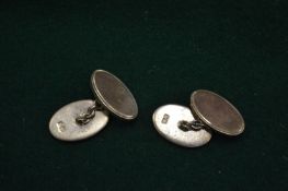 A pair of heavy silver cufflinks.