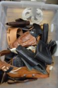 A large collection of leather holsters.