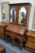 A good 18th century walnut bureau cabinet on stand with a pair of mirrored doors enclosing a
