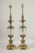 A PAIR OF BRASS AND GLASS COLUMN LAMPS with pineapple finials. 70cms high.