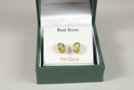 A PAIR OF 9CT GOLD OVAL PERIDOT EARRINGS.