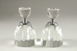A PAIR OF CRYSTAL CUT CIRCULAR SCENT BOTTLES.