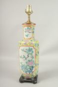 A CHINESE YELLOW GROUND PORCELAIN LAMP on a wooden base. 56cms high.