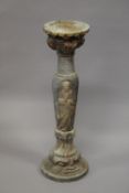 A MARBLE COLUMN, the sides curved with Chinese figures with circular top and base. 94cm high.
