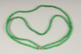 A DOUBLE ROW OF JADE BEADS with white gold clasp.
