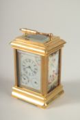 A SMALL BRASS CARRIAGE CLOCK with three dials and Sevres design porcelain panels to the sides.