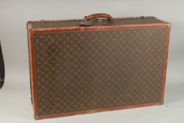 A LOUIS VUITTON SUITCASE with leather handle and brass mounts. 80cms long x 50cms wide x 25cms