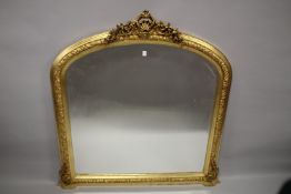A DECORATIVE 19TH CENTURY GILTWOOD OVERMANTLE MIRROR. 134cms high x 130cms wide.