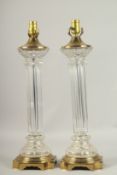 A PAIR OF 1920'S BRASS AND GLASS COLUMN LAMPS. 60cms high.