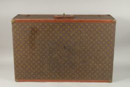 A LOUIS VUITTON SUITCASE with leather handle and brass mounts. 80cms long x 50cms wide x 25cms