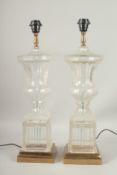 A GOOD PAIR OF GLASS URN SHAPED LAMPS on metal bases. 60cms high.