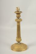 A GOOD EMPIRE METAL CANDLESTICK converted to a lamp, on a circular base. 33cms high.