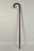 A 19TH CENTURY HORSE MEASURING WALKING STICK in a briar wood case with metal sliding measure.