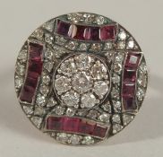 AN UNHALLMARKED ROSE GOLD SILVER TOPPED CIRCULAR ART DECO STYLE RING set with calibre-cut rubies and