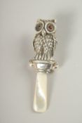 A SILVER AND MOTHER-OF-PEARL OWL RATTLE.