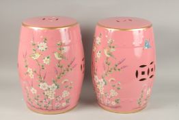 A PAIR OF CHINESE PINK PORCELAIN BARREL SEATS with flowers and birds. 46cms high.